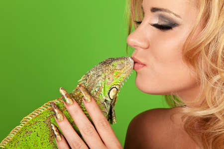 12389278-portrait-of-a-young-woman-with-beautiful-manicure-kissing-a-iguana.jpg