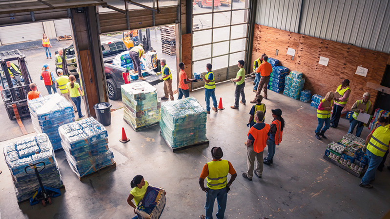 En un almacén, varios Testigos juntan provisiones para ayuda humanitaria.