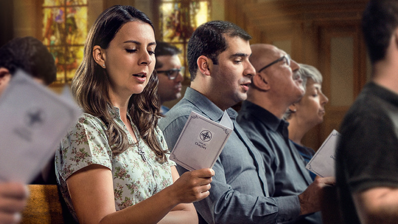 Un grupo de personas en una iglesia recitando oraciones de un libro.