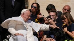 ARCHIVO - El papa Francisco acaricia a un perro guía durante su audiencia general semanal en la Plaza de San Pedro, en el Vaticano, el 31 de mayo de 2023.